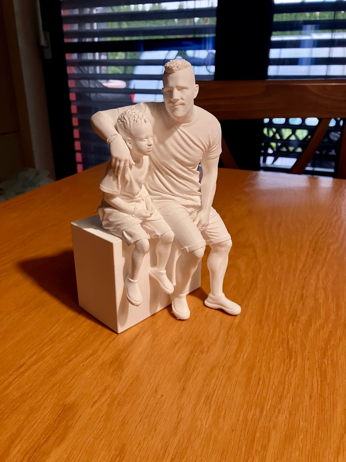 Full view of a white figurine showing two seated people