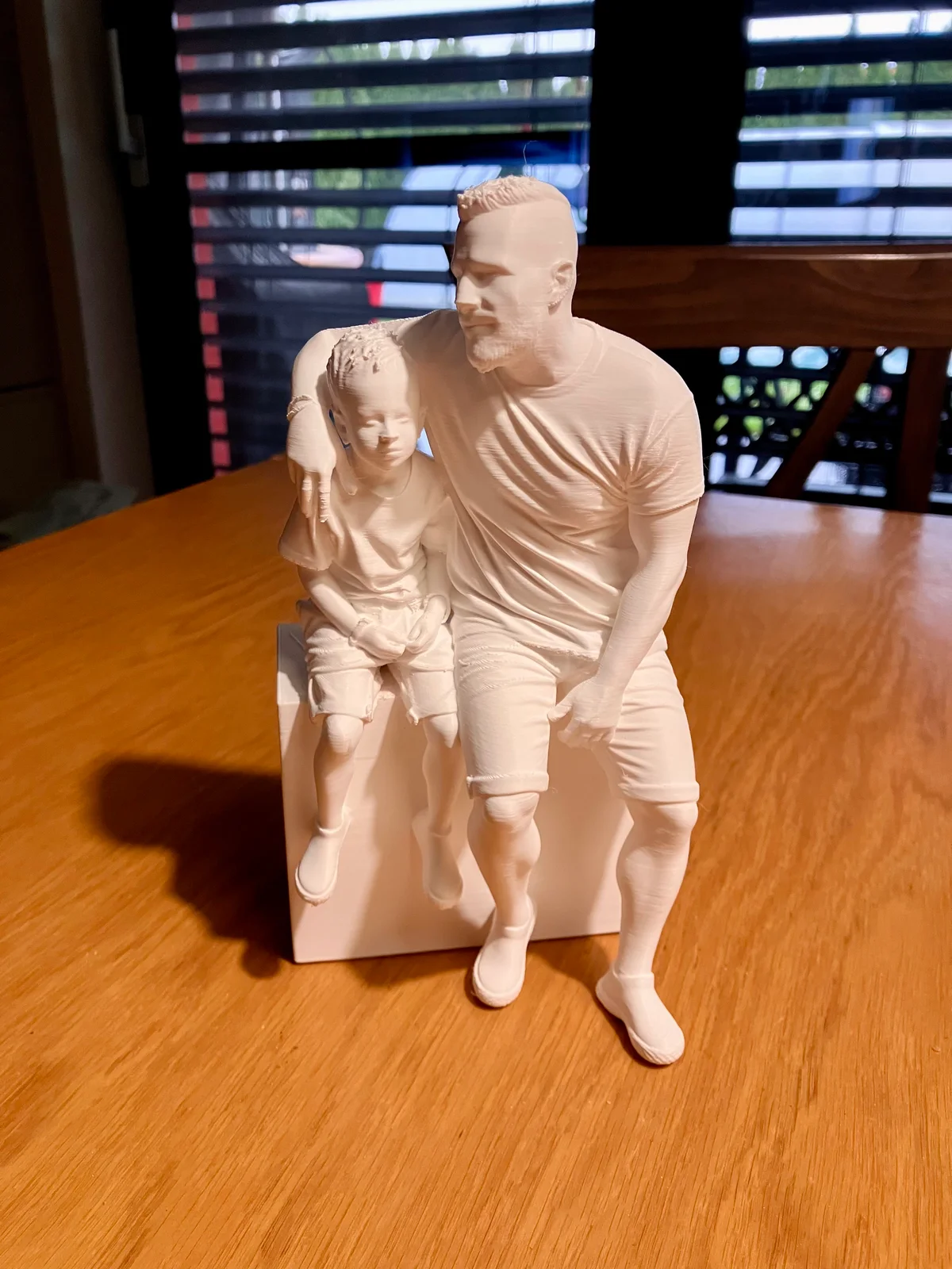 Angled view of the family figurine showing faces and clothing